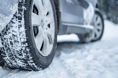 「今年は雪が降らない」と思っていたのに、季節外れの雪にびっくり！「スタッドレスタイヤ」は前2本だけの装着だと罰金になる？ 注意点を解説